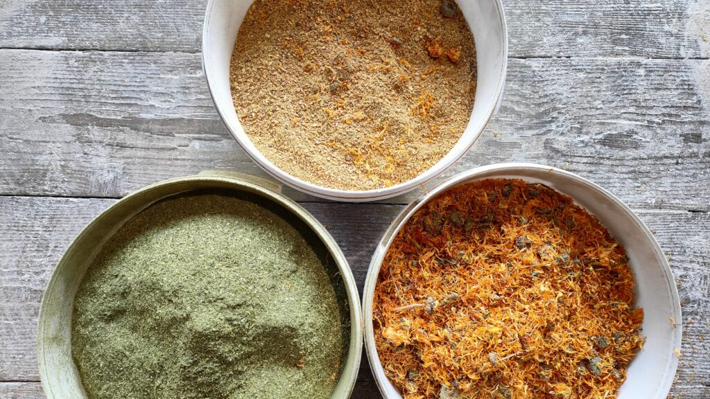 naturalne dodatki ziołowe podawane kurczakom na drewnianej podłodze w czystych białych wiaderkach